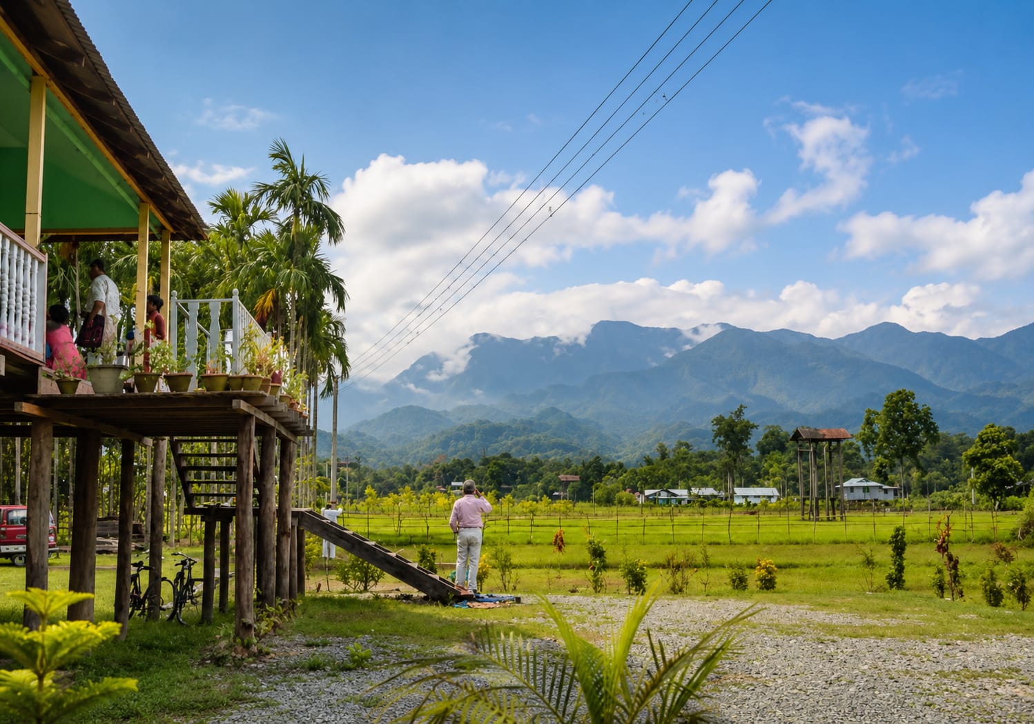 A stilt house with a verandah above paddy fields at Raimatang, with the Bhutan hills behind