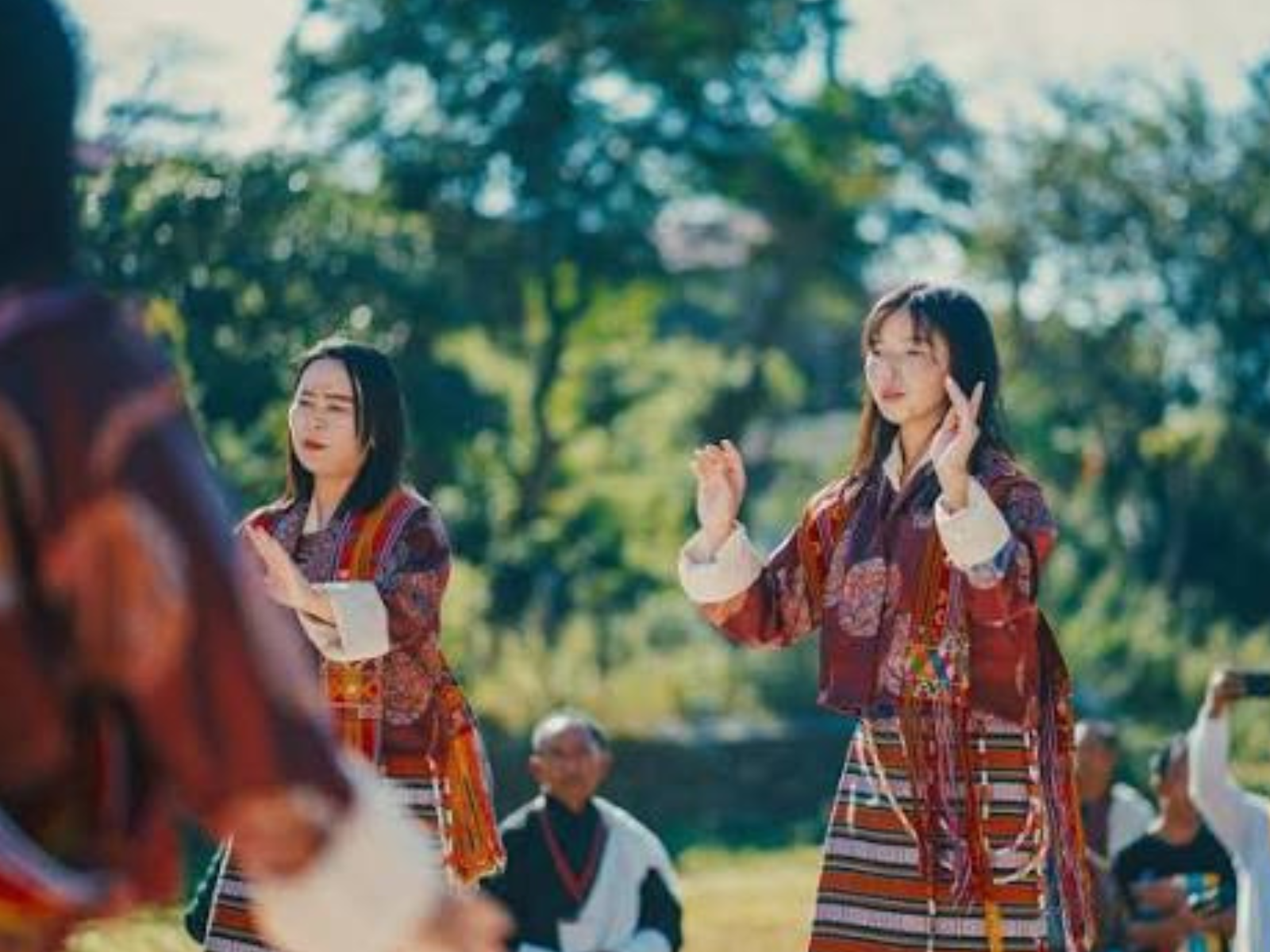 Young women dancing in traditional Drukpa dress at a village gathering