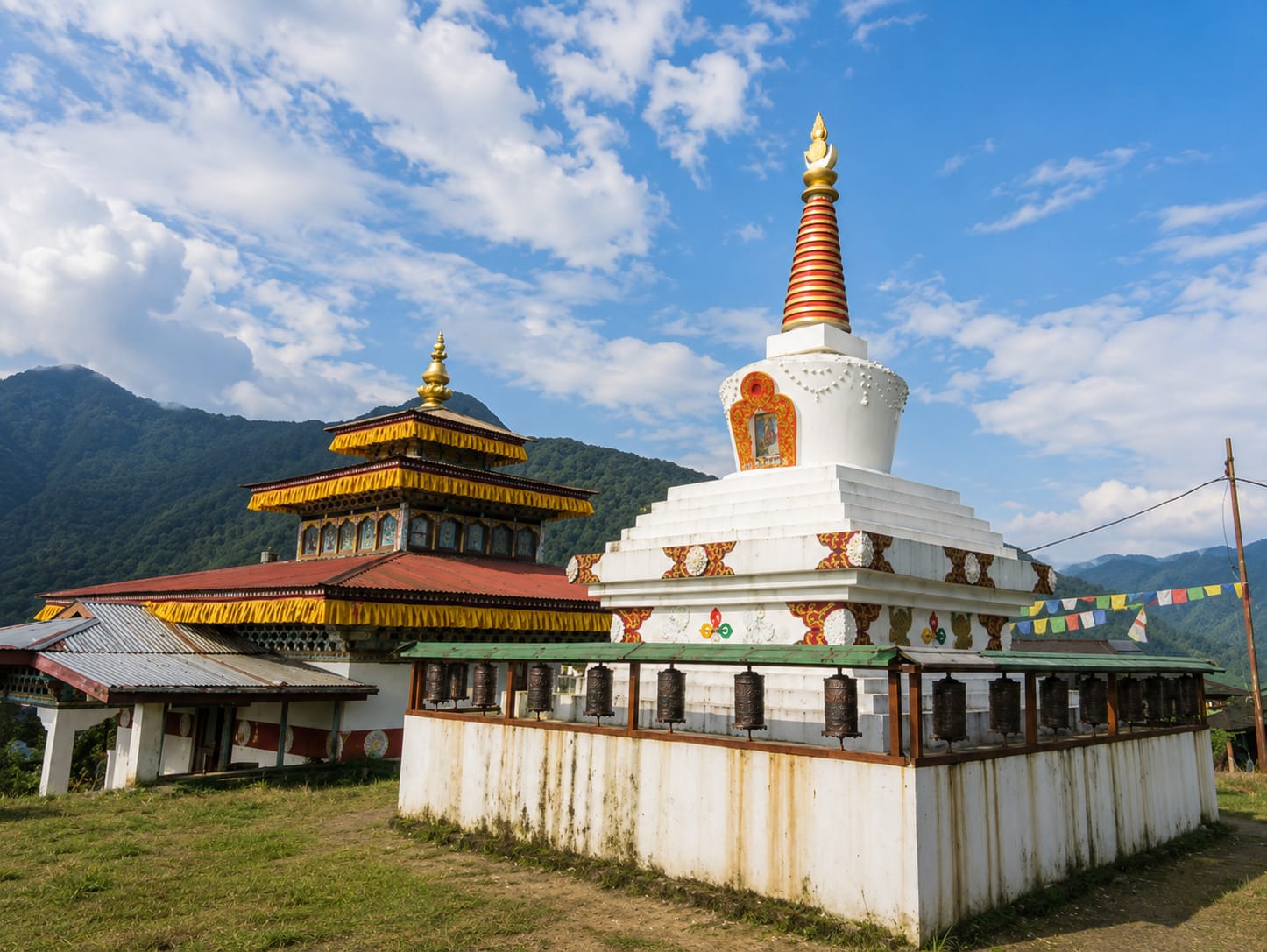 The whitewashed stupa, prayer wheels and gilded monastery roof at Buxa Duar