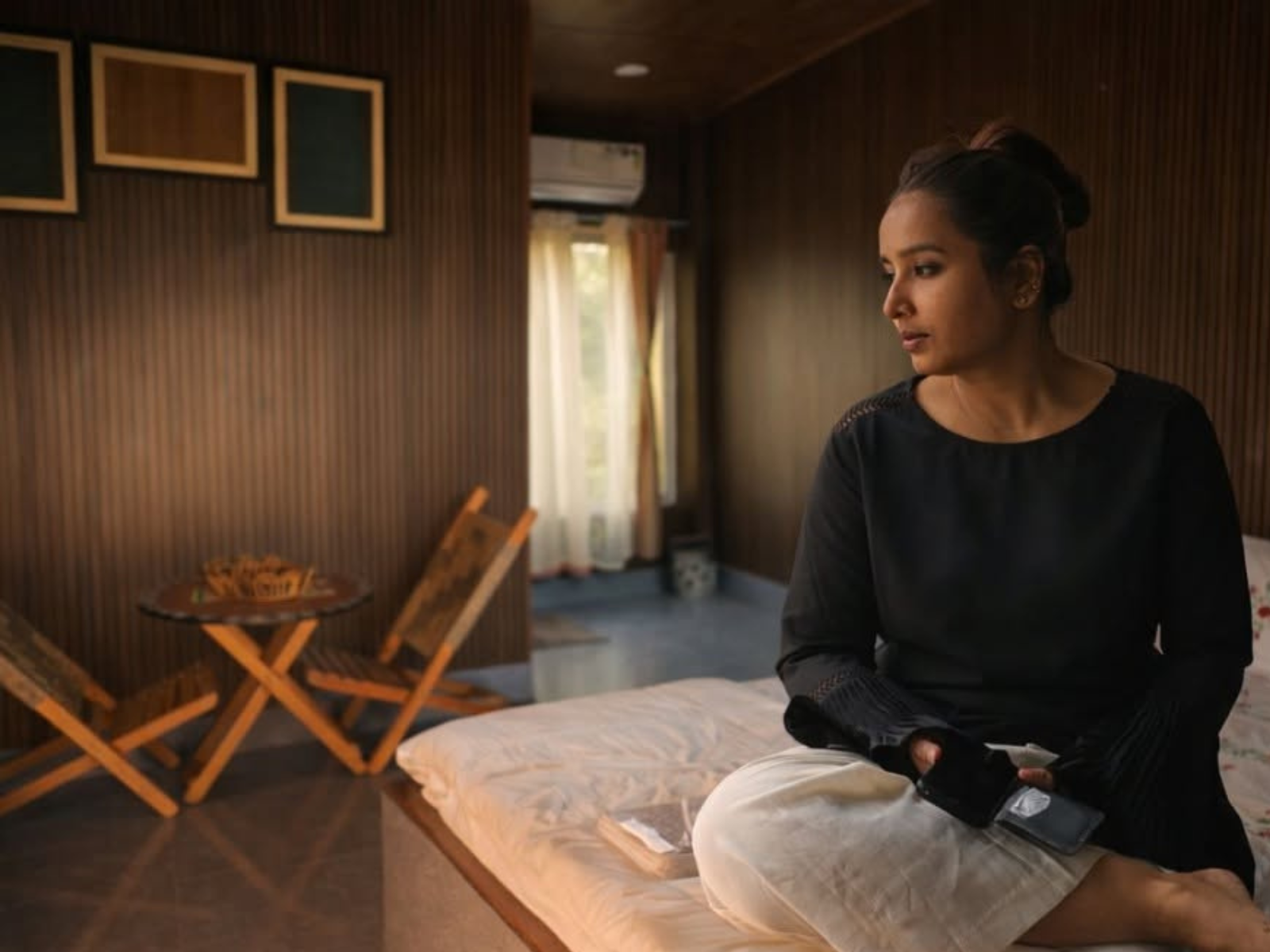 Deluxe Room interior with wood-panelled walls, cane folding chairs and a painted table