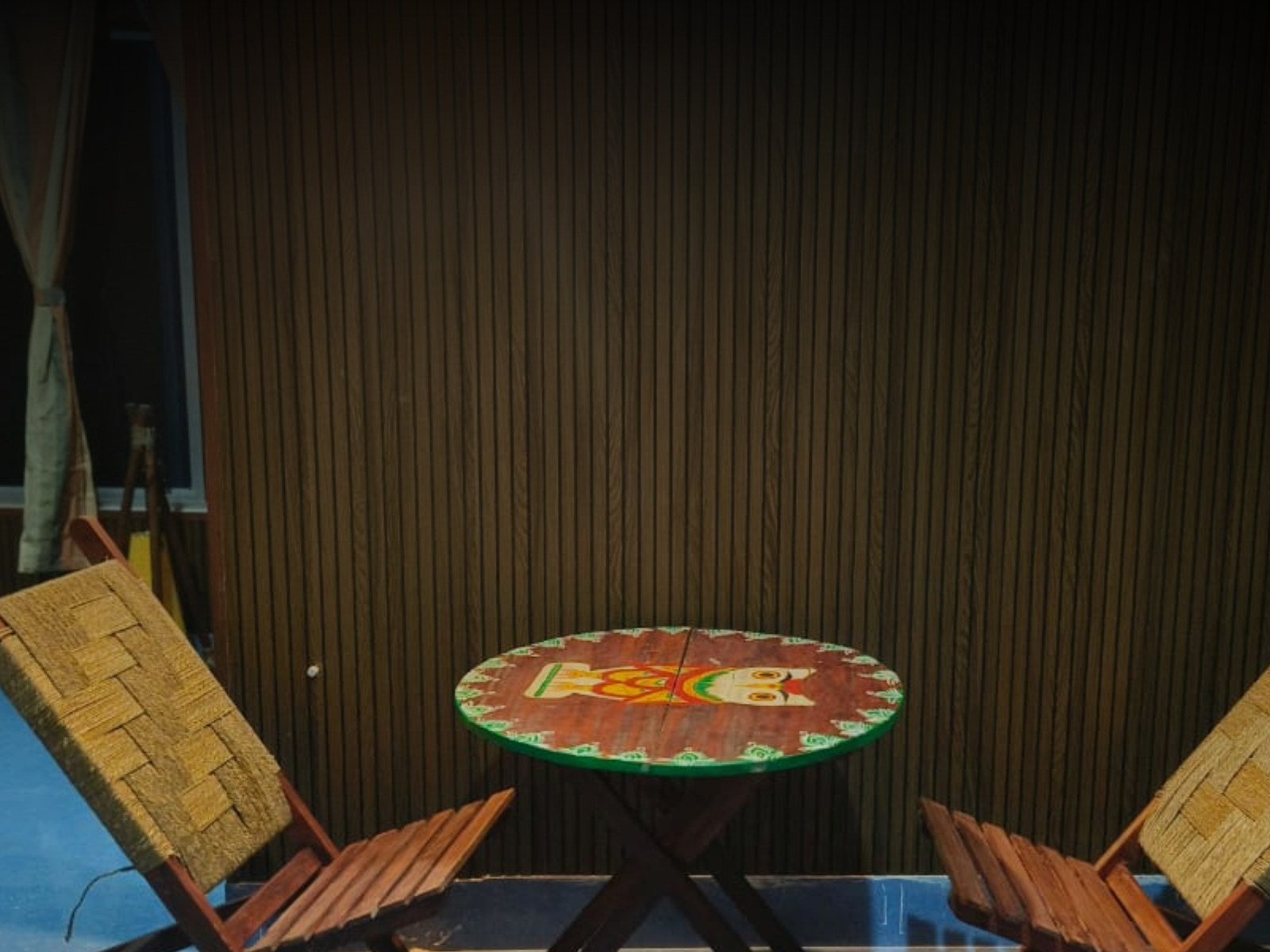 Cane chairs and a hand-painted folding table in the Deluxe Room