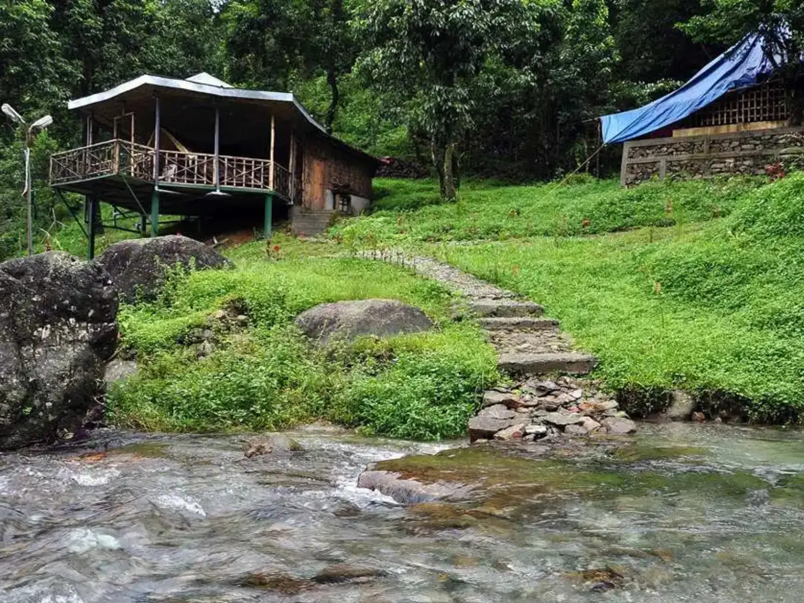 A stilted bamboo cottage above a clear forest stream at Suntalekhola near Samsing
